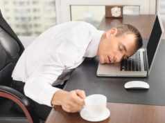 Homem dormindo com a cabeça em cima do notebook