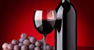 Garrafa de vinho, taça com vinho e uvas