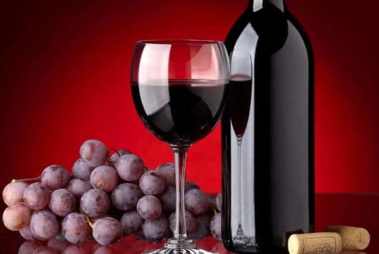 Garrafa de vinho, taça com vinho e uvas