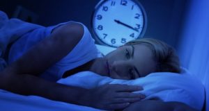 Mulher com insônia deitada na cama