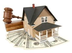 Miniatura de casa, martelo de leilão e notas de dólar