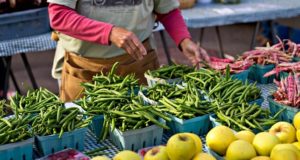 Feirante manipulando vegetais